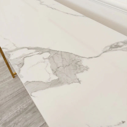 Add instant glamour to your home with this Console Table, featuring a bold, squared geometric frame in a radiant gold finish and a sleek Polar White Sintered Stone top. Shop online today at www.nobleandnook.co.uk