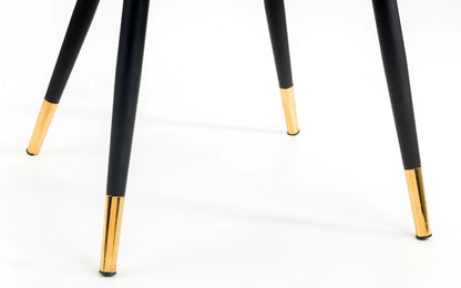 The Hadid Dining Chair brings sophistication to your space with its soft green velvet upholstery and eye-catching black-and-gold leg design. Pair them with a sleek dining table. Shop online today at www.nobleandnook.co.uk
