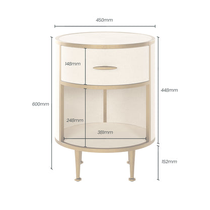 The Hampton Bedside Table features a sleek round design with a single drawer, crafted in ivory faux shagreen and brass accents. Shop online now at www.nobleandnook.co.uk
