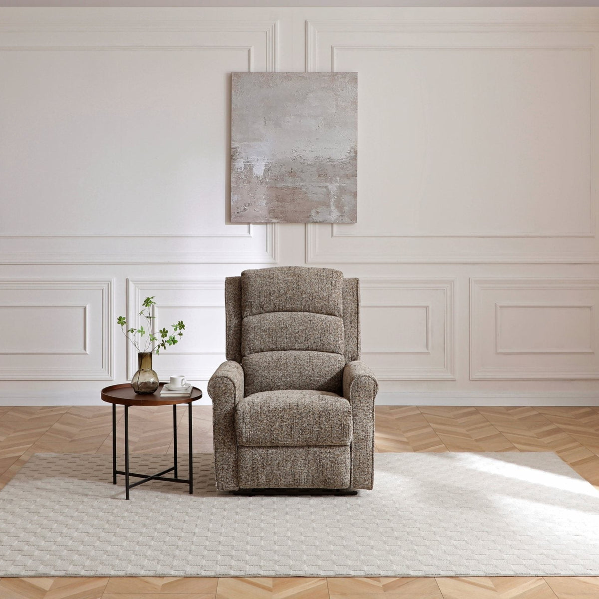 Gray armchair in a room with white walls and wooden floor.