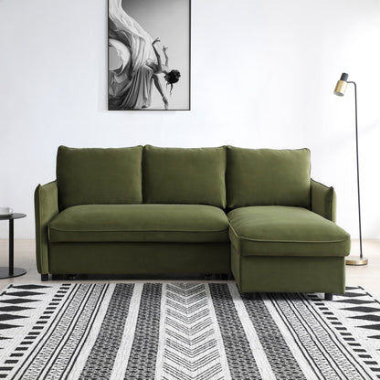 Green sectional sofa in a room with a patterned rug and artwork on the wall.
