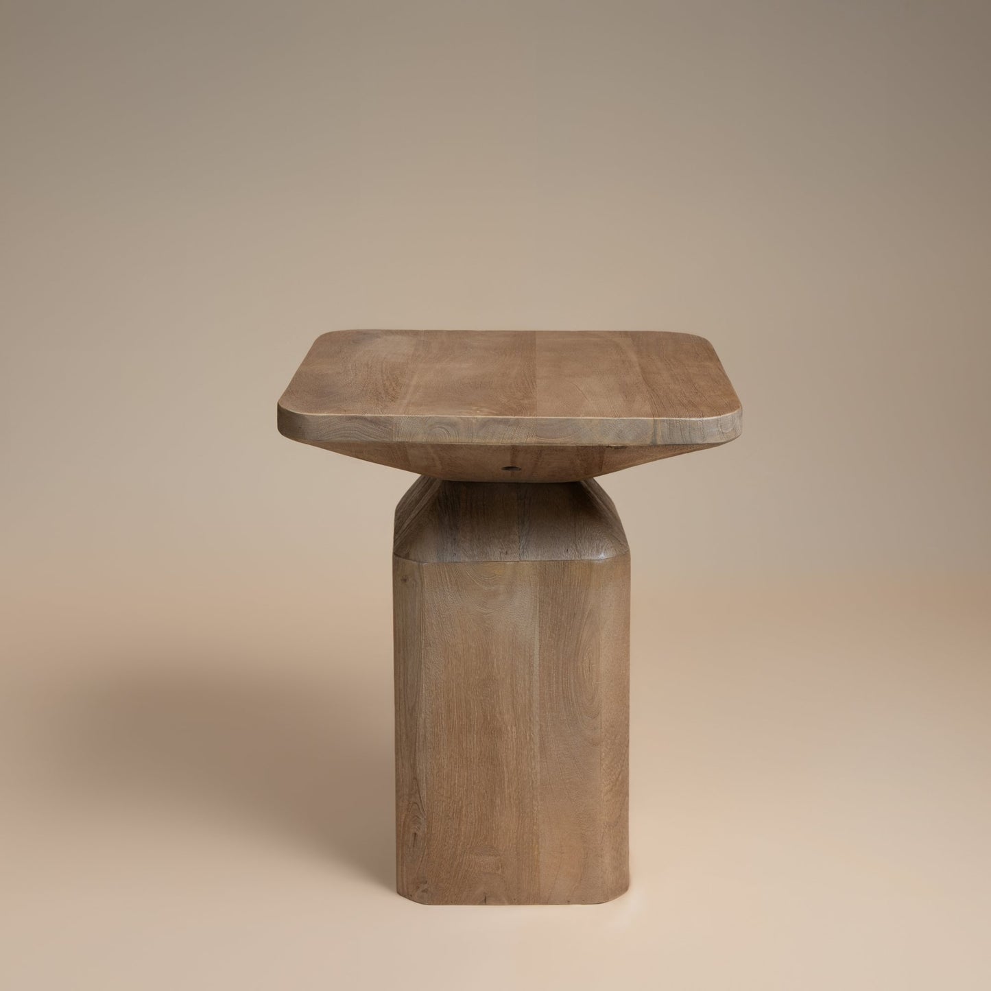 Wooden side table with a square top and cylindrical base on a beige background