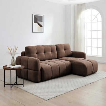 A modern brown tufted sectional sofa with a chaise lounge, styled in a bright, minimalist living room with a side table, patterned rug, and large arched window.
