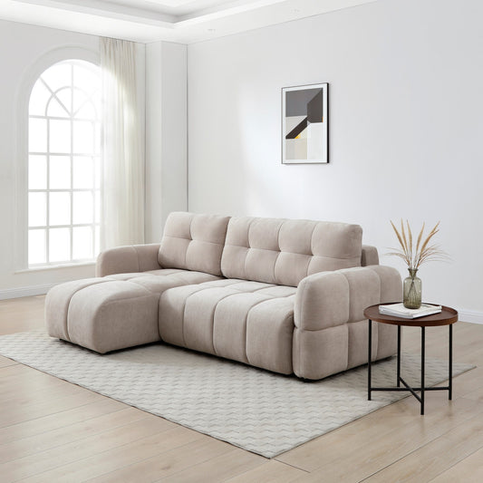 Beige sectional sofa in a modern living room with a side table and decorative elements.