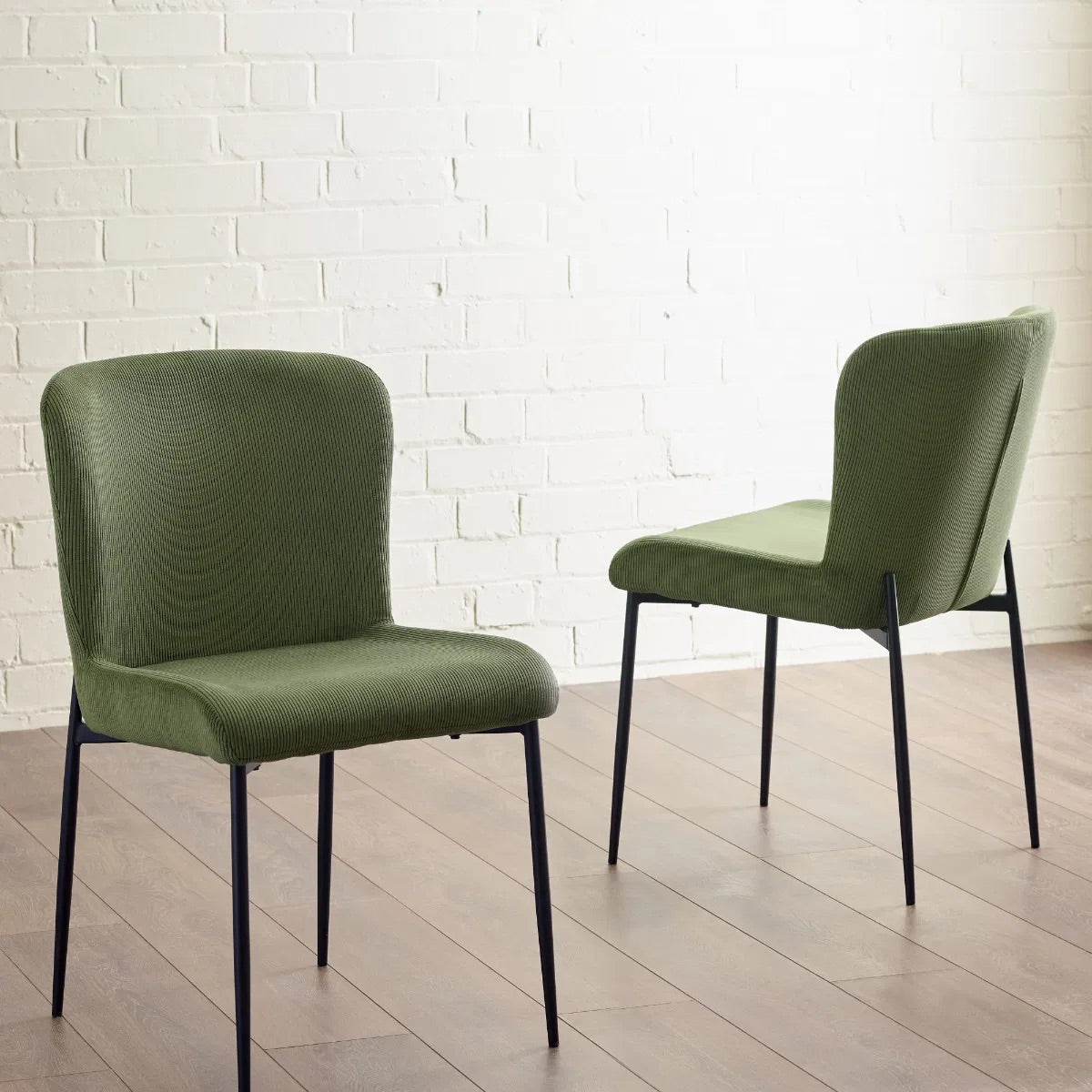 Shop the Leonie Dining Chair in green velvet and bring a sophisticated statement to your dining space. Featuring a plush, curved design and slender black legs. Shop online today at www.nobleandnook.co.uk