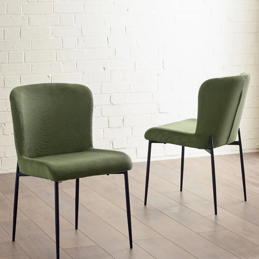 Shop the Leonie Dining Chair in green velvet and bring a sophisticated statement to your dining space. Featuring a plush, curved design and slender black legs. Shop online today at www.nobleandnook.co.uk
