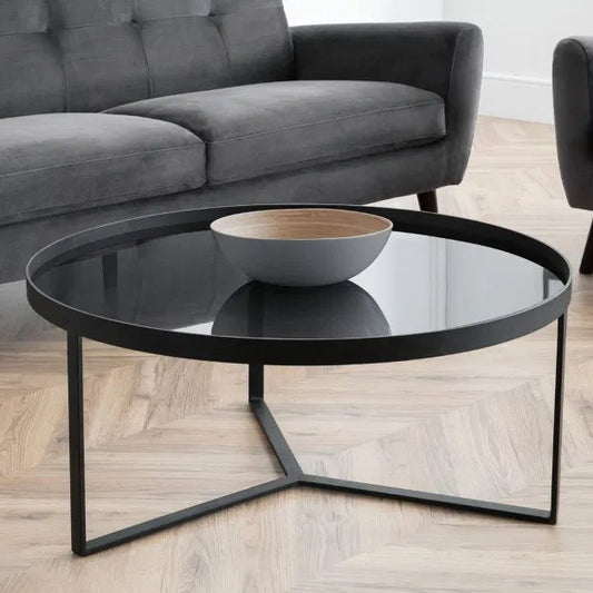 Shop the Soho Coffee Table, a perfect blend of sophistication, featuring a geometric black metal base and a smoked tempered glass top. Shop Online today at www.nobleandnook.co.uk