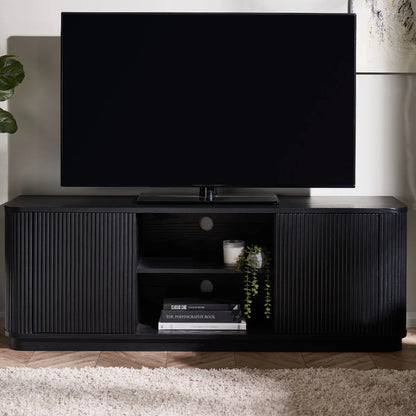Black TV stand with a television on top in a room setting.