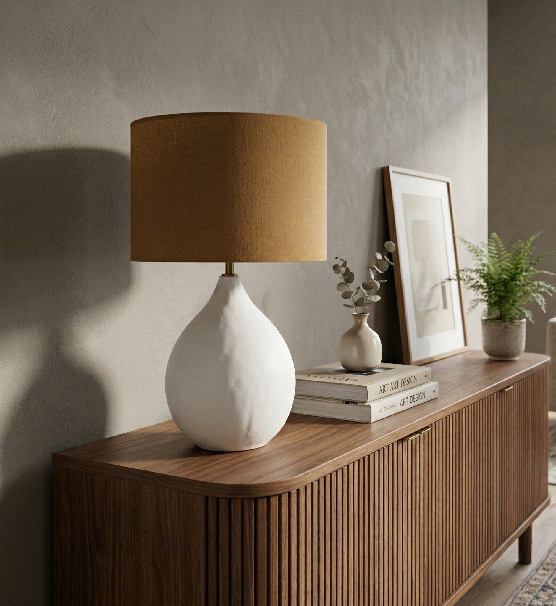 White ceramic lamp with a brown lampshade on a wooden sideboard in a living room.