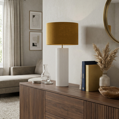 Living room with a wooden sideboard, lamp, books, and decorative items.