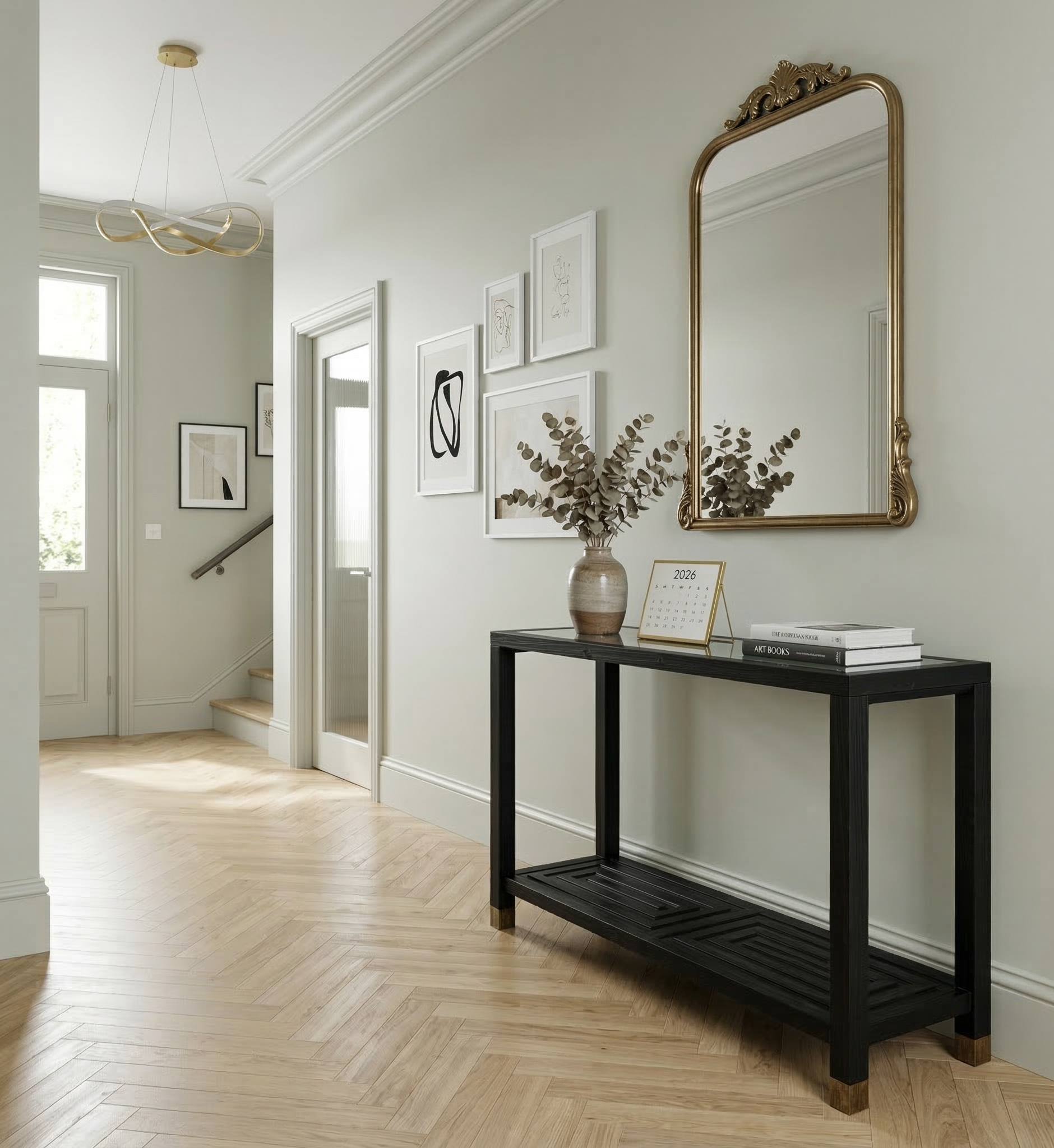 Modern interior with a black console table, gold-framed mirror, and decorative items.