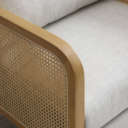 Shop the Mabel Rattan Accent Chair, a unique piece featuring a padded back and seat adorned with a bolster cushion, all resting on a stained wooden frame. Shop online now at www.nobleandnook.co.uk