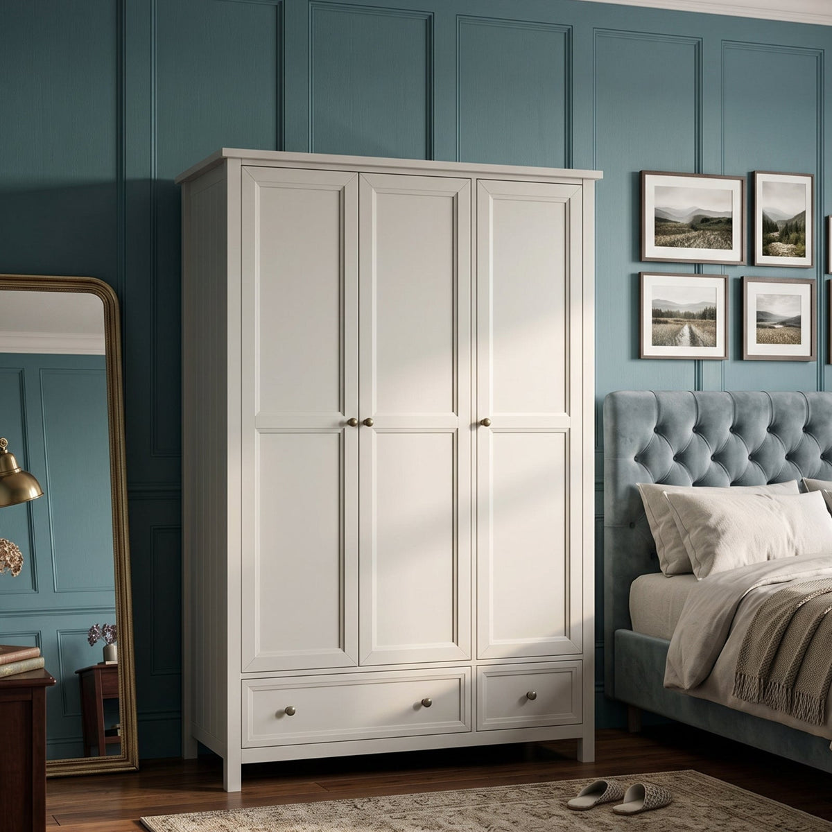 A tall white 3-door wardrobe with two lower drawers, styled in a bedroom next to a blue tufted bed, a wooden side table with a mirror, and teal paneled walls.