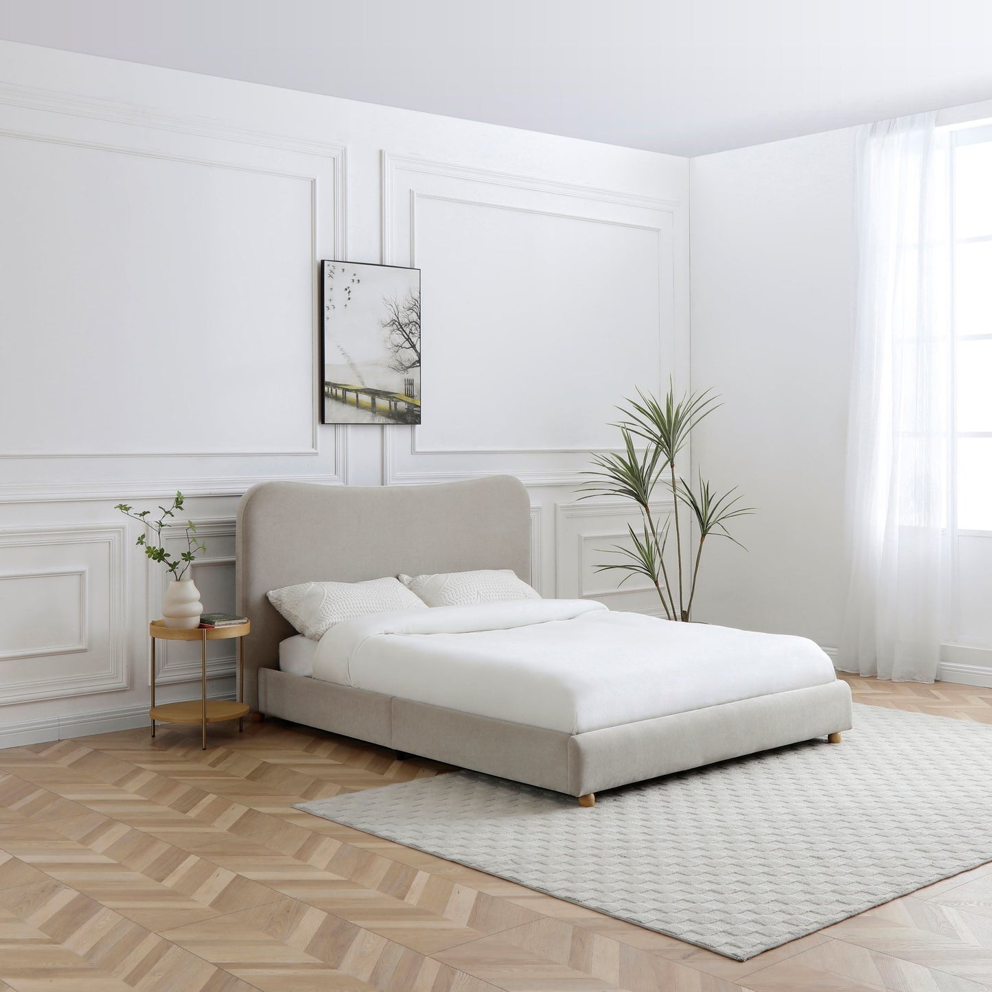 Modern bedroom with a beige upholstered bed, white bedding, and minimal decor.