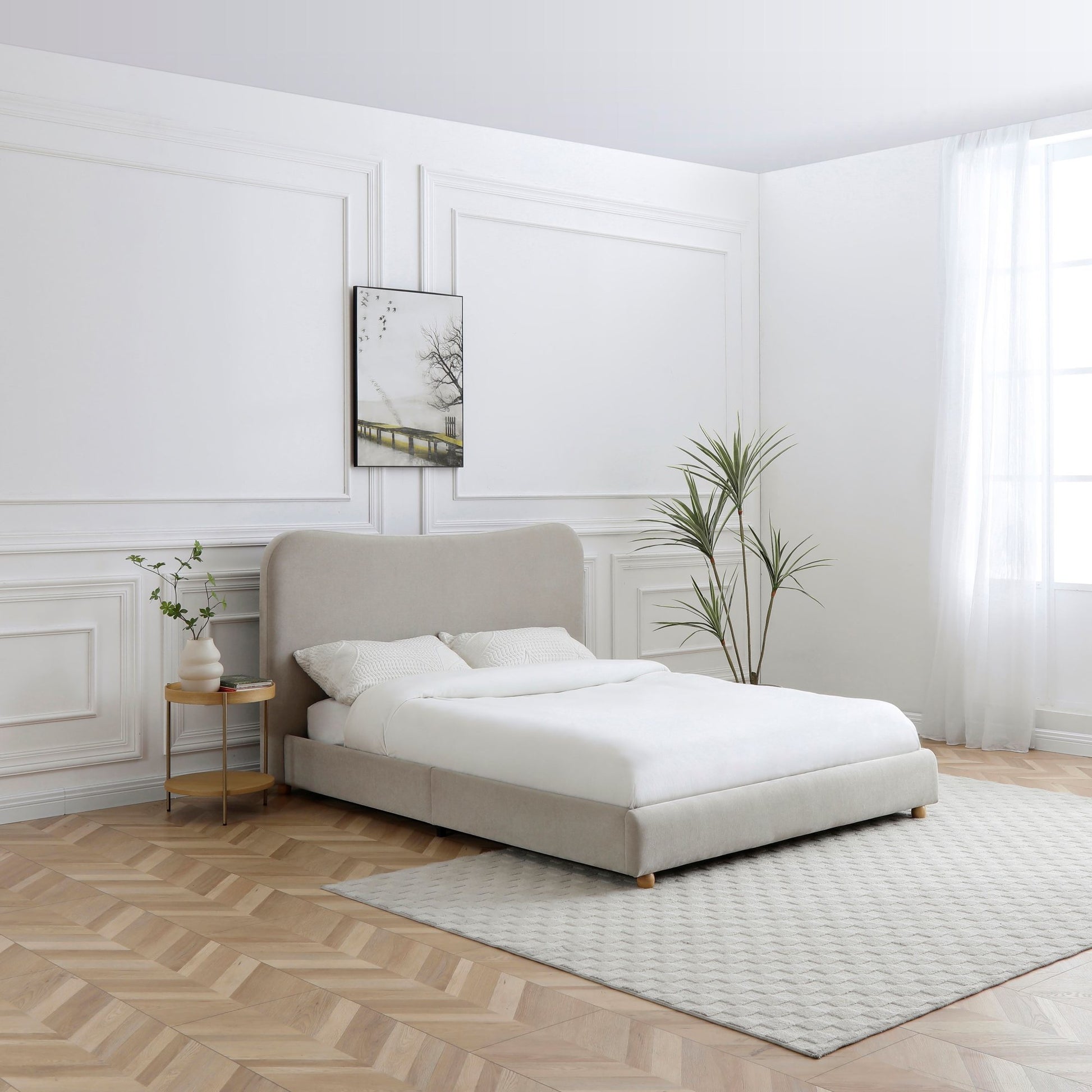 Modern bedroom with a beige upholstered bed, white bedding, and minimal decor.