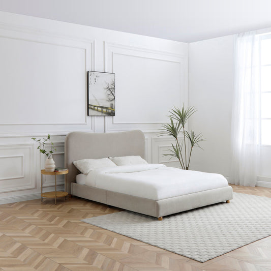 Modern bedroom with a beige upholstered bed, white bedding, and minimal decor.