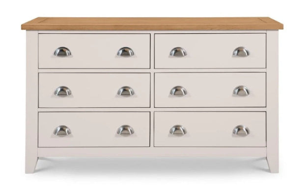 White dresser with six drawers and a wooden top on a white background