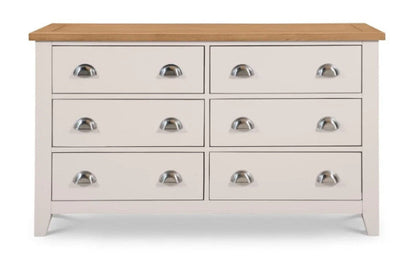 White dresser with six drawers and a wooden top on a white background