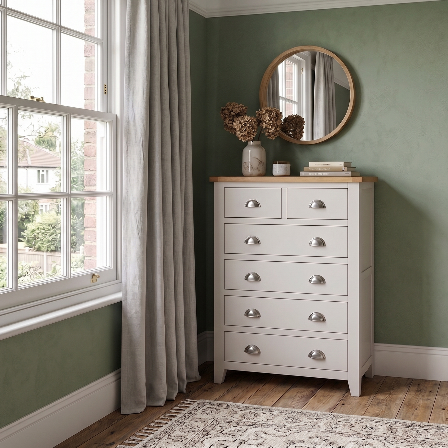 Bedroom with a white dresser and bed against a green wall.