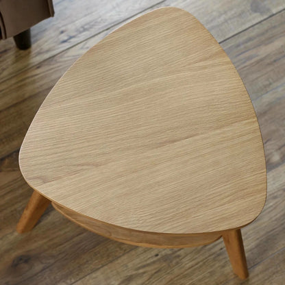 The Vera Side three-legged Table, featuring a rattan-inspired shelf and a warm natural wood finish.  Perfect for smaller spaces. Available at www.nobleandnook.co.uk