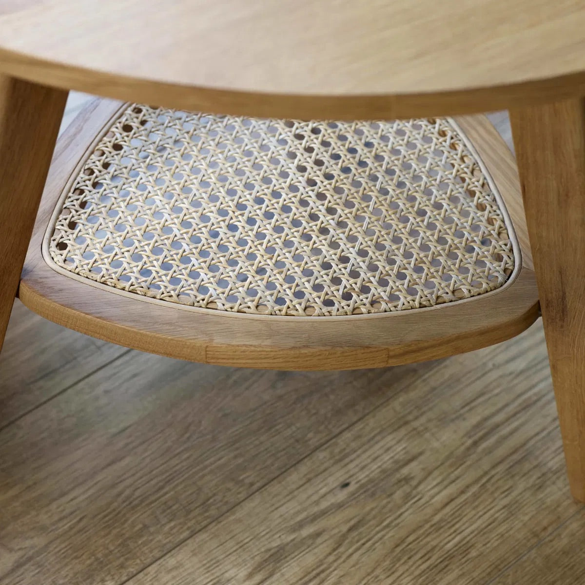The Vera Side three-legged Table, featuring a rattan-inspired shelf and a warm natural wood finish.  Perfect for smaller spaces. Available at www.nobleandnook.co.uk