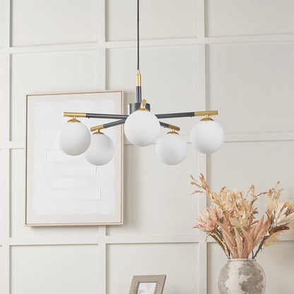 Modern chandelier with white spherical lights on a neutral wall with decorative elements.