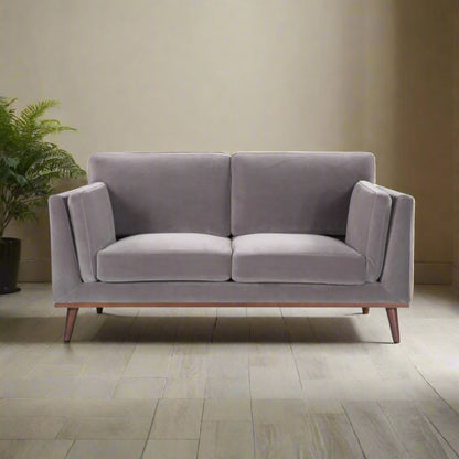 Shop the Mickey 2 seater sofa in Stone Grey velvet with a walnut frame and tapered walnut legs, a contemporary masterpiece. Shop online today at www.nobleandnook.co.uk