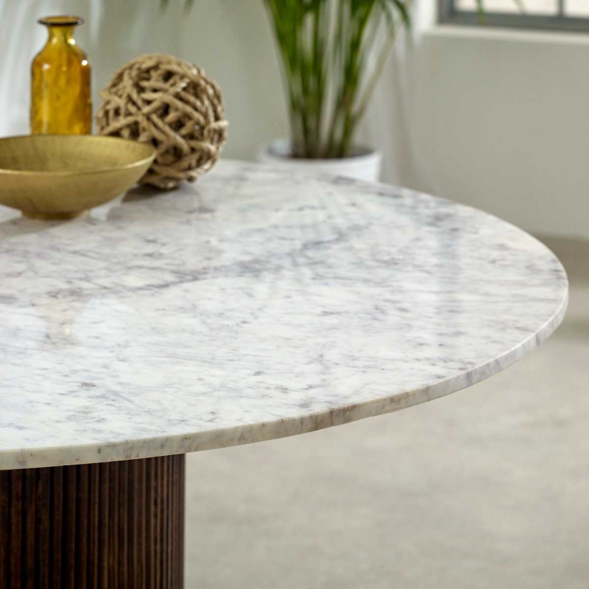 Luxurious white marble top with a sculptural base crafted from 100% solid mango wood for textural depth. Handmade in India using eco-friendly materials. H76×W120×D120cm. www.nobleandnook.co.uk