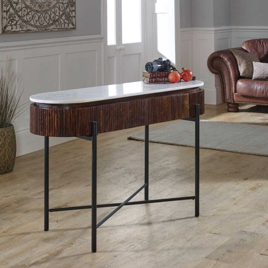 The handmade Opal Console Table with smooth marble top nests within a beautifully fluted mango wood frame, all supported by refined metal legs. H77×W120×D40 cm. Shop online today at www.nobleandnook.co.uk